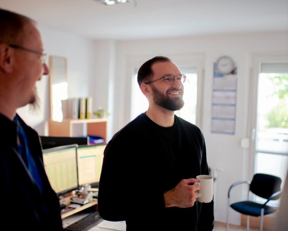 Bauhof West Bauleiter mit Tasse im Gespräch